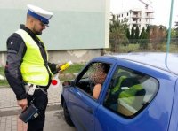 Policjant ruchu drogowego sprawdza stan trzeźwości kierującej