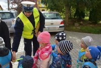 Policjant RD przekazuje dzieciom elementy odblaskowe