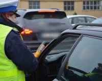 Policjantka z Wydziału Ruchu Drogowego kontroluje trzeźwość kierowcy