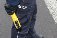 Policjant, trzymający w ręku alkomat