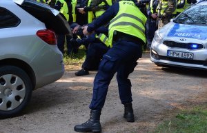 Policjanci sprawdzają porzucony w lesie samochód osobowy