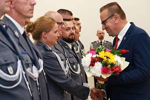 Przewodniczący Rady Miejskiej wręcza kwiaty policjantce
