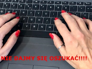 Dłonie z pomalowanymi na czerwono paznokciami na klawiaturze, czerwony napis: nie dajmy się oszukać