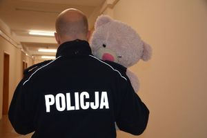 Policjant niesie różowego misia